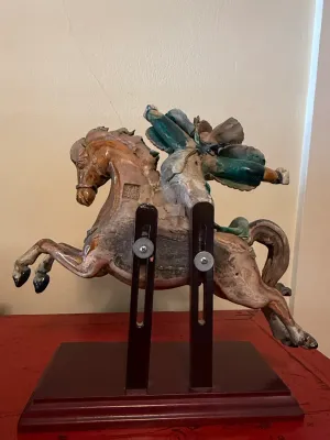 Sale Photo Thumbnail #149: Vintage Asian glazed ceramic sculpture depicting a rider on a rearing horse, mounted on a custom dark wooden display stand.