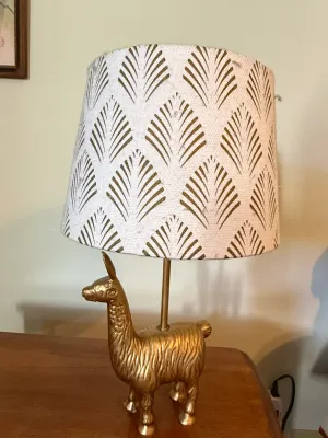 Sale Photo Thumbnail #367: Whimsical brass llama table lamp paired with a patterned fabric lampshade featuring a gold geometric palm motif.