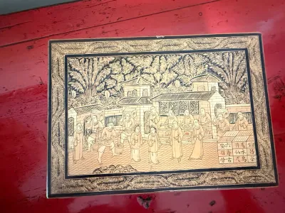 Sale Photo Thumbnail #129: Vintage Asian black and gold incised lacquered wooden box featuring a detailed village scene with Chinese figures and characters.