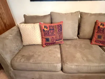 Sale Photo Thumbnail #214: Contemporary taupe microfiber couch styled with patterned boho decorative throw pillows.
