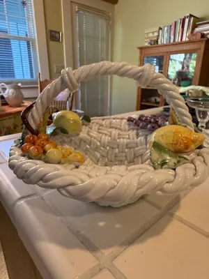Sale Photo Thumbnail #495: Italian-style woven ceramic fruit basket with twisted handle, adorned with relief lemons, grapes, and peaches.