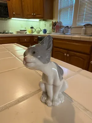 Sale Photo Thumbnail #499: Glazed porcelain cat figurine in grey and white, featuring a glossy finish and stylized design.