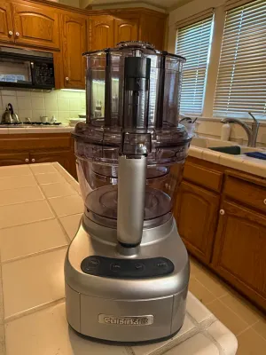 Sale Photo Thumbnail #437: Cuisinart food processor with brushed stainless-style finish and tinted work bowl, sitting on a kitchen countertop.