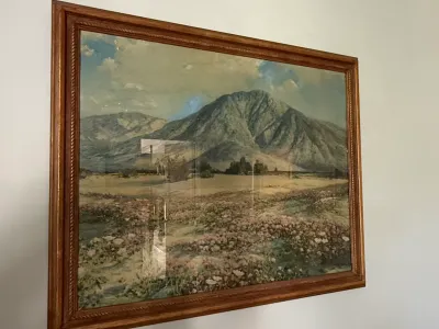 Sale Photo Thumbnail #315: Framed landscape art print featuring a mountain scene with a field of wildflowers in the foreground, housed in a molded wooden frame.