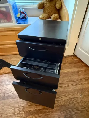 Sale Photo Thumbnail #362: Black metal three-drawer rolling filing cabinet with curved handles and top lock mechanism.