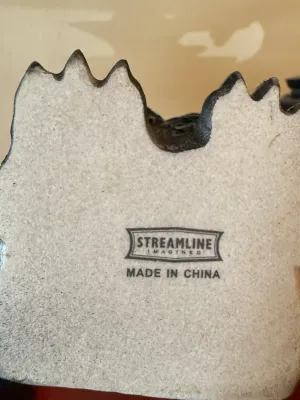 Sale Photo Thumbnail #156: Underside of a Streamline Imagined decorative ceramic item displaying manufacturer stamp and "Made in China" label.
