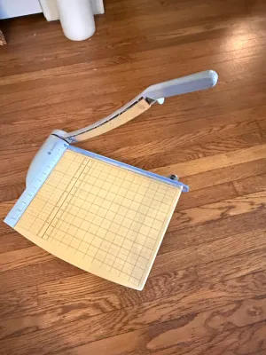 Sale Photo Thumbnail #359: Quartet heavy-duty guillotine paper trimmer with grid lines resting on a hardwood floor.