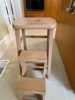 Sale Photo Thumbnail #432: Vintage painted wooden step stool with fluted legs and pull-out steps, showing some light surface wear and finish loss.