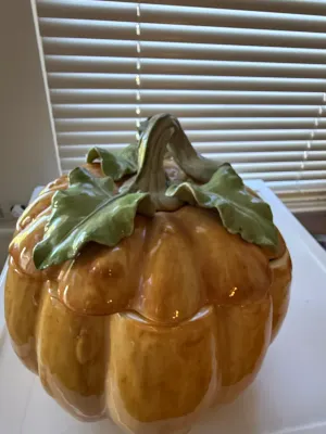 Sale Photo Thumbnail #351: Large glazed ceramic pumpkin cookie jar or tureen featuring embossed green leaf and stem handle detailing on the lid.