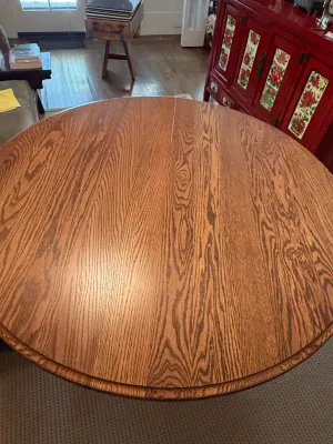 Sale Photo Thumbnail #165: Round solid oak dining table featuring prominent wood grain and a smooth polished finish.
