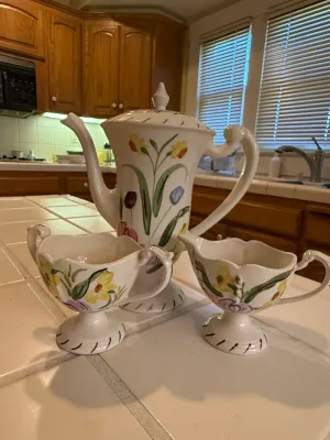 Sale Photo Thumbnail #476: Three-piece hand-painted ceramic coffee service set, featuring a lidded coffee pot, creamer, and sugar bowl with colorful floral motifs.