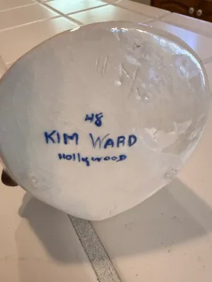 Sale Photo Thumbnail #496: Underside of a ceramic piece featuring an artist signature reading '48 Kim Ward Hollywood' over a glazed white base with fine crazing.