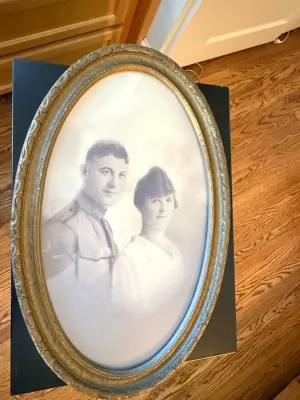 Sale Photo Thumbnail #341: Antique oval-framed black-and-white portrait of a World War I era military couple, housed in a molded gesso and gilt wood frame.