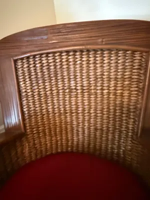Sale Photo Thumbnail #190: Vintage wicker or rattan barrel chair featuring a dark wood frame and a red upholstered seat cushion.