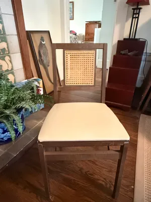 Sale Photo Thumbnail #243: Mid-century modern style wooden dining chair featuring a cane inset backrest and light-colored upholstered seat.