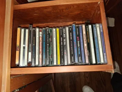 Sale Photo Thumbnail #96: Collection of music CDs in jewel cases stored inside a wooden drawer, including titles by Norah Jones, Garth Brooks, and Harry Belafonte.