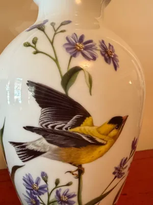 Sale Photo Thumbnail #135: Hand-painted porcelain vase featuring a detailed goldfinch amidst purple wildflowers against a glossy white background.