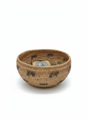 Sale Photo Thumbnail #23: Hand-woven Native American coiled basket bowl with dark geometric motifs, containing a small framed vintage portrait photo.