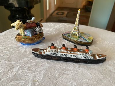 Collection of three hand-painted Limoges-style porcelain trinket boxes, featuring designs of Noah's Ark, the Eiffel Tower on a map...