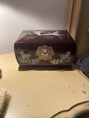 Korean black lacquer jewelry box featuring mother-of-pearl inlay of cranes and floral motifs with decorative brass hardware.