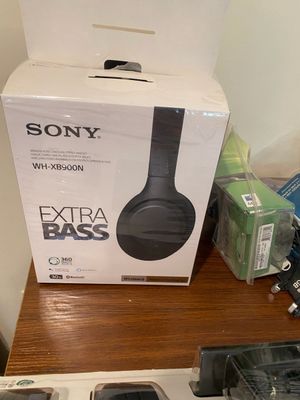 Sony WH-XB900N Extra Bass wireless noise-canceling headphones in original packaging, shown alongside small boxed electronics.