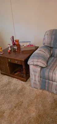 Sale Photo Thumbnail #20: Vintage dark stain wooden end table with carved details alongside a Southwestern pattern upholstered armchair.