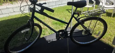 Sale Photo Thumbnail #62: Vintage dark green Norco step-through mountain bicycle featuring a rear cargo rack, kickstand, and wide padded seat.