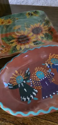 Sale Photo Thumbnail #15: Hand-painted terra cotta dish featuring stylized figures alongside a square floral sunflower glass plate.