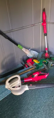 Sale Photo Thumbnail #57: Collection of electric outdoor power equipment, including leaf blowers, hedge trimmers, and a string trimmer.