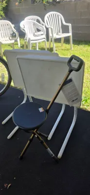 Sale Photo Thumbnail #61: Drive Medical folding cane seat with a round black plastic top, positioned in front of white adjustable TV tray tables.