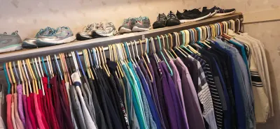 Sale Photo Thumbnail #46: Closet rack packed with color-coordinated casual clothing on hangers, topped with an array of athletic shoes.