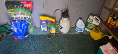 Sale Photo Thumbnail #55: Collection of lawn and garden care products, including Spectracide Triazicide insect killer, a pump sprayer, Simple Green cleaner, and a yellow plastic watering can.