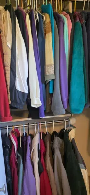 Sale Photo Thumbnail #39: Closet filled with assorted outerwear and casual clothing hanging on upper and lower rods, including fleece jackets, windbreakers, and sweaters in various colors.