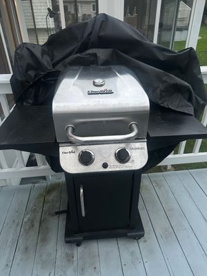 Sale Photo Thumbnail #46: Char-Broil Performance two-burner propane gas grill with stainless steel lid, side shelves, and a fitted black vinyl protective cover.