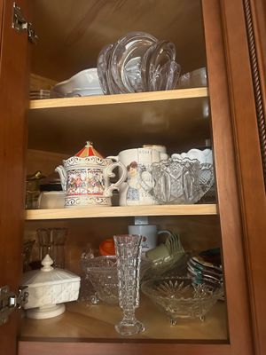 Sale Photo Thumbnail #50: Wooden display cabinet filled with vintage glassware, including cut crystal bowls, a decorative carousel teapot, milk glass pieces, and small bud vases.