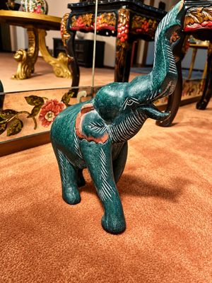 Sale Photo Thumbnail #18: Hand-carved green stone elephant figurine with raised trunk and white incised accents.