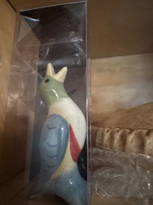 Sale Photo Thumbnail #48: Hand-painted ceramic bird pie vent, featuring a colorful design with a green head and blue wings, stored in a clear protective box.