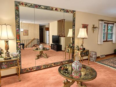 Sale Photo Thumbnail #4: Large three-panel wall mirror featuring a floral-painted border, accompanied by a matching ornate end table, table lamp, and glass-top coffee table in Chinoiserie style.