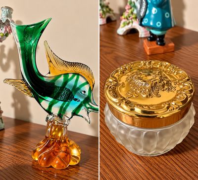 Sale Photo Thumbnail #12: Murano-style blown art glass fish figurine alongside a vintage frosted glass vanity powder jar with an ornate gold-tone lid.
