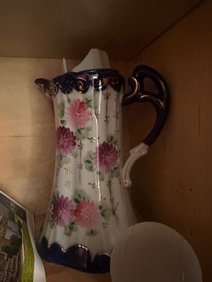 Sale Photo Thumbnail #49: Vintage hand-painted porcelain pitcher featuring floral designs, cobalt blue accents, and gilded scroll detailing.