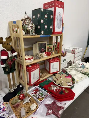 Sale Photo Thumbnail #18: Collection of holiday and Christmas decorations, including boxed Santa figurines, gingerbread plush ornaments, stocking hangers, small ceramics, and festive linens.