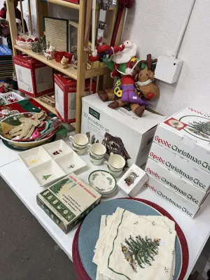 Sale Photo Thumbnail #17: A collection of Christmas tabletop items and holiday decor, featuring Spode Christmas Tree dishware, cloth napkins, placemats, and boxed nativity sets.