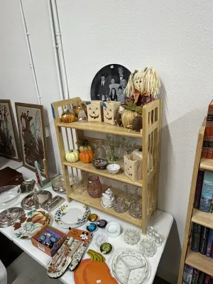 Sale Photo Thumbnail #2: Collection of fall decor, glassware, and tableware, including jack-o'-lantern lanterns, artificial pumpkins, rag dolls, silver-plated serving pieces, and Disney kitchenware.