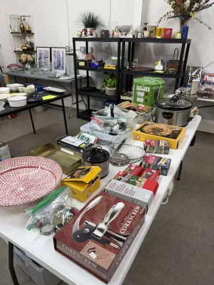 Sale Photo Thumbnail #6: Assorted household items and kitchenware, including a boxed corkscrew set, slow cooker, wire baskets, decorative ceramic bowls, and outdoor light clips.