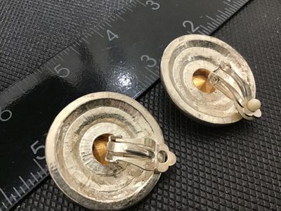 Sale Photo Thumbnail #133: Pair of vintage silver-tone clip-on earrings featuring concentric rings of sparkling pave rhinestones surrounding a central faceted rhinestone. Measures approximately 1.25 inches in diameter. Clip backs appear functional; light vintage wear consistent wit