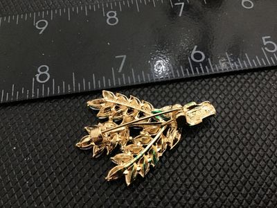 Sale Photo Thumbnail #88: A gold-tone floral bouquet or wheat-spray style brooch set with marquise-cut purple and green rhinestones, accented with clear round rhinestones at the stem wrapper. Measures approximately 2 inches in length. Standard pin back with rollover safety clasp. 