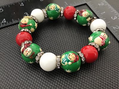 Sale Photo Thumbnail #14: Festive stretch bracelet featuring hand-painted style snowman beads, solid red and white accent beads, and rhinestone spacer rings. In good condition with light wear consistent with age and use.