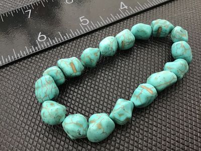 Sale Photo Thumbnail #66: A stretch beaded bracelet featuring freeform light blue/turquoise style nugget beads with brown veining and matrix throughout. Measures approximately 6 to 7 inches unstretched. Good condition with light wear.