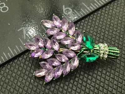 Sale Photo Thumbnail #87: A gold-tone floral bouquet or wheat-spray style brooch set with marquise-cut purple and green rhinestones, accented with clear round rhinestones at the stem wrapper. Measures approximately 2 inches in length. Standard pin back with rollover safety clasp. 