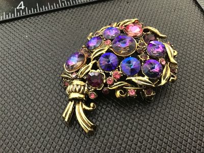 Sale Photo Thumbnail #42: Vintage gold-tone floral bouquet brooch set with vibrant purple, lavender, and pink rhinestones. Signed Hollycraft on the reverse. Features a rollover safety clasp. Measures approximately 2 inches in size. Pre-owned condition with light surface wear consi